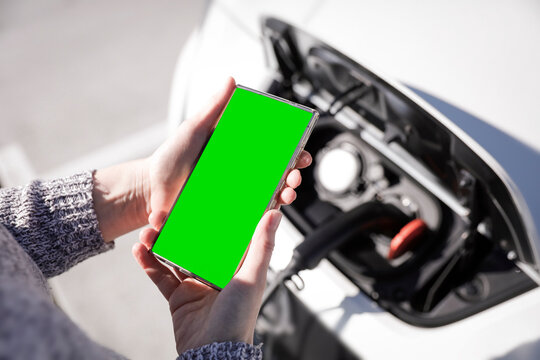 Data Set Training &ndash; woman charging electric car with EV charging station. Parking area background, providing a realistic everyday environment for electric vehicle charging.