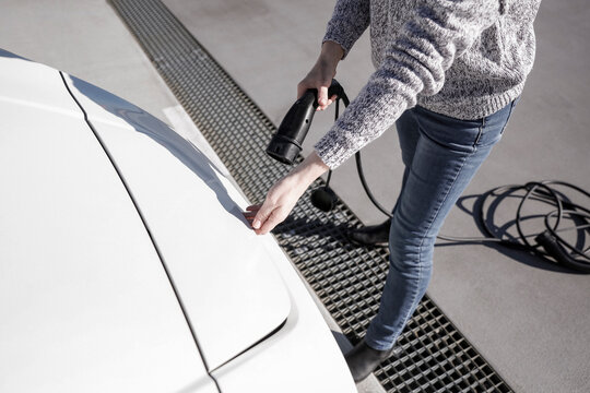 Data Set Training &ndash; woman charging electric car with EV charging station. Parking area background, providing a realistic everyday environment for electric vehicle charging.