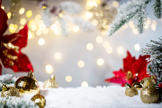 Christmas Holiday background with snow, fir tree and decorations with christmas light behind