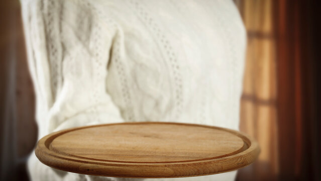 Woman holding wooden tray with copy space &ndash; cozy winter interior concept.