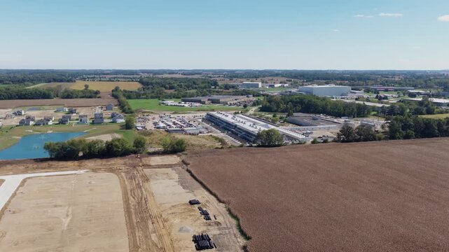 Drone aerial establishing view of large white data center construction being built in central Ohio by Springfield, OH near countryside rural country landscape of tech data building for AI hardware 4k