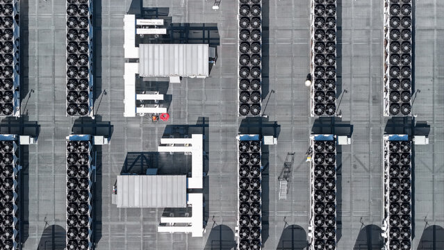 Aerial view of rows of industrial HVAC cooling fans on a flat data center rooftop in San Jose, California, United States.
