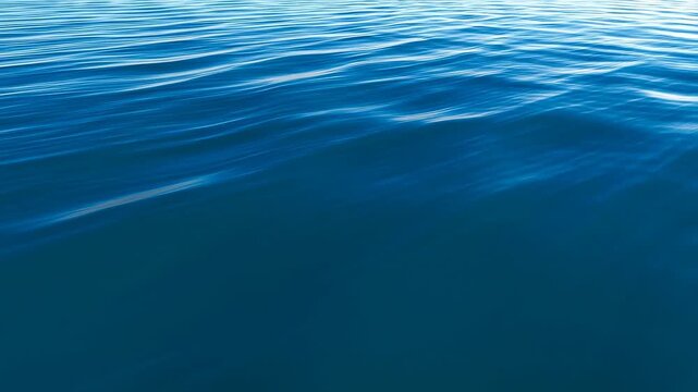 Calm ocean water surface with gentle ripples and small waves flowing smoothly across the frame. Natural light reflection adds depth and energy to the animated scene.