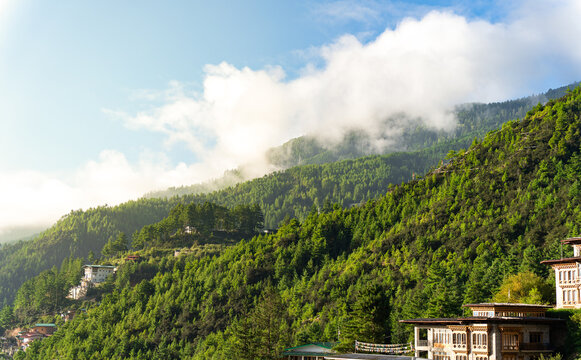 City view of Thimphu, Bhutan, Viewpoint on SEP 2026, Scenic green mountains with morning clouds and traditional hillside buildings, sustainability, zero carbon, negative carbon