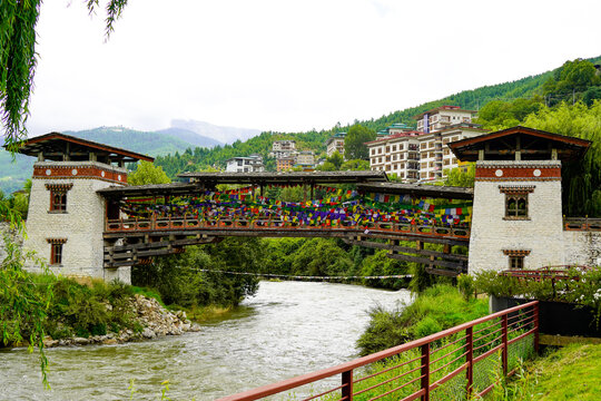 Changjiji Traditional Bridge, Traditional wooden covered bridge over river with colorful prayer flags in mountain town, Thimphu, Bhutan, SEP 2026