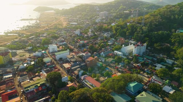 Cinematic aerial footage of Coron, Palawan, Philippines, showing the dense waterfront neighborhoods and numerous traditional outrigger boats along the coast of Busuanga Island.