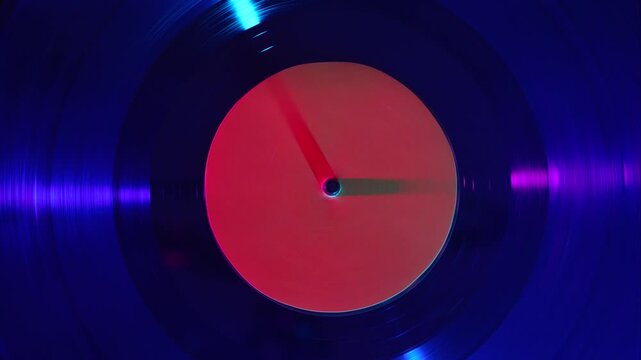 Vinyl record spinning under colorful light