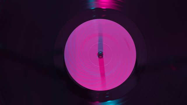 Close up of vinyl record under colorful light