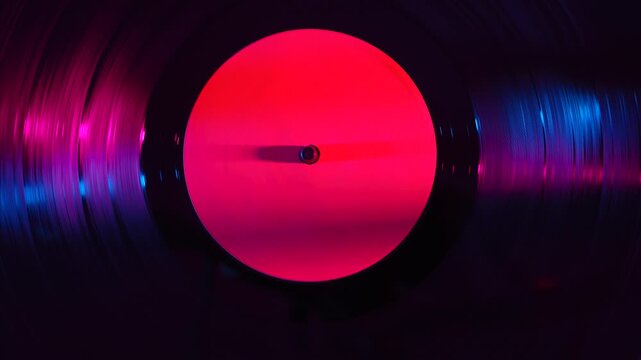 Vinyl record spinning under colorful light