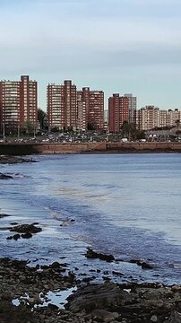 Waterfront boardwalk buildings and clam waters of river plate river in montevideo city, uruguay