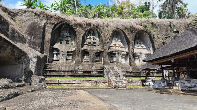 Ancient rock-cut candi shrines at Gunung Kawi temple in Bali, Indonesia, featuring carved stone cliffs, traditional Balinese architecture, historic cultural heritage site, serene outdoor atmosphere