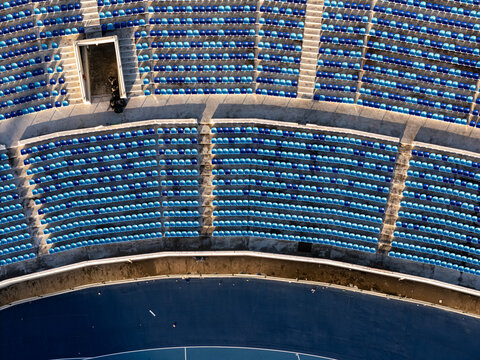 Aerial view of the blue and light blue plastic seats arranged in curved rows at a stadium in Santo Domingo, Distrito Nacional, Dominican Republic.