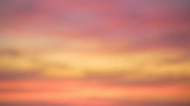 A soft focus sunset sky displays layers of pink orange and golden yellow clouds.