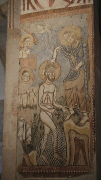 Ancient religious frescoes on stone pillars inside the Romanesque crypt of San Fermo Church in Verona, Veneto.