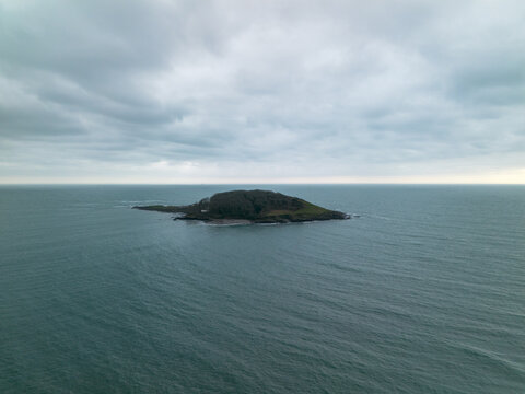 Aerial view of Looe Island surrounded by the sea under an overcast sky in Looe, Cornwall, United Kingdom.