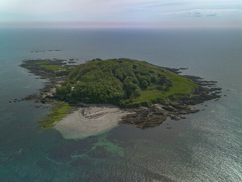 Aerial view of Looe Island surrounded by rocky coastline and clear blue sea in Looe, Cornwall, United Kingdom.