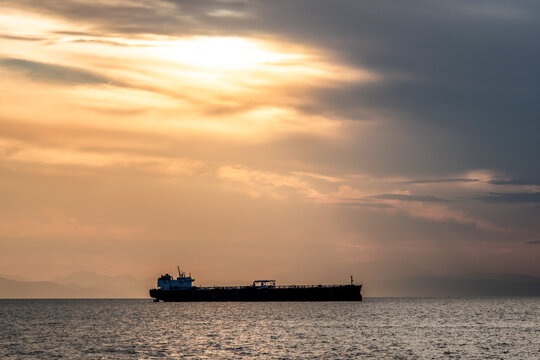Crude oil tanker in the sea at fiery sunset. Oil and gas industry. Tankers crude oil carrier ship designed for transporting grude oil