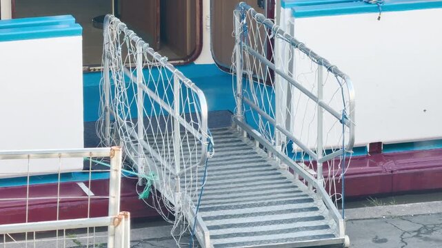 A metal gangway leads aboard a cruise ship in Saint Petersburg. It invites passengers to start a peaceful river trip. Travelers feel safe, calm, and excited for their journey.