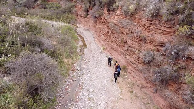 Group of four friends hiking along mountain stream in C&oacute;rdoba, Argentina