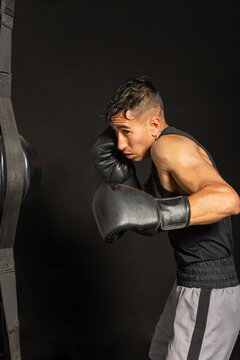 Hispanic boxer ready to strike speed bag in profile