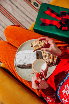 Woman enjoy stollen and milk beside Christmas gift