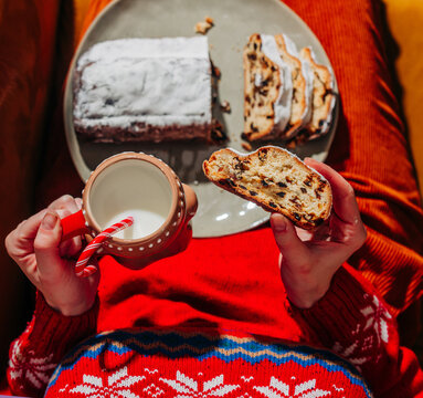 Woman enjoy stollen and milk in festive sweater