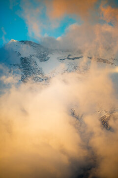 Snowy Cotopaxi volcano above golden cloudscape in Ecuador