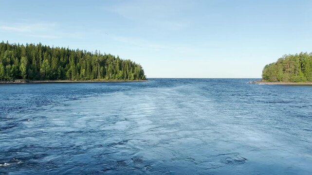 A water channel flows between forested shores at Valaam, Lake Ladoga. This scenic view brings calm and peaceful feelings during an inspiring journey.