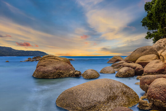 Long Exposure Seascape of Kata Beach with Rocky Shoreline and Tropical Forest, Phuket, Thailand