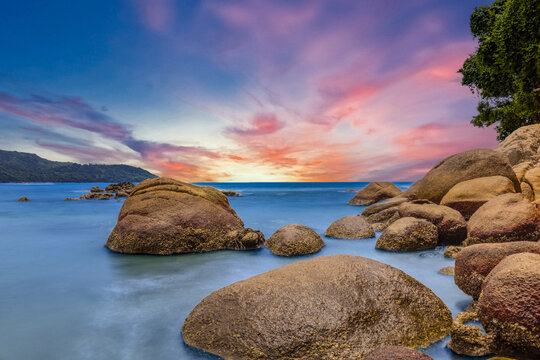 Long Exposure Seascape of Kata Beach with Rocky Shoreline and Tropical Forest, Phuket, Thailand