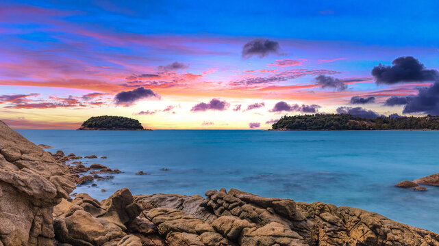 Long Exposure Seascape of Kata Beach with Rocky Shoreline and Tropical Forest, Phuket, Thailand