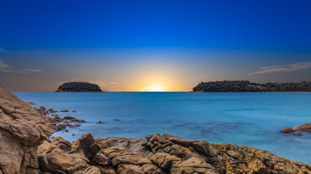 Long Exposure Seascape of Kata Beach with Rocky Shoreline and Tropical Forest, Phuket, Thailand