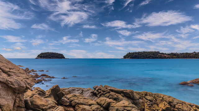 Long Exposure Seascape of Kata Beach with Rocky Shoreline and Tropical Forest, Phuket, Thailand