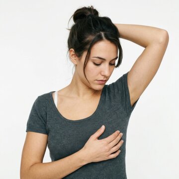 Woman performs self examination of breast and armpit checking for lumps or abnormalities Health awareness and medical checkup concept