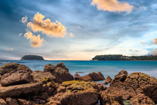 Long Exposure Seascape of Kata Beach with Rocky Shoreline and Tropical Forest, Phuket, Thailand