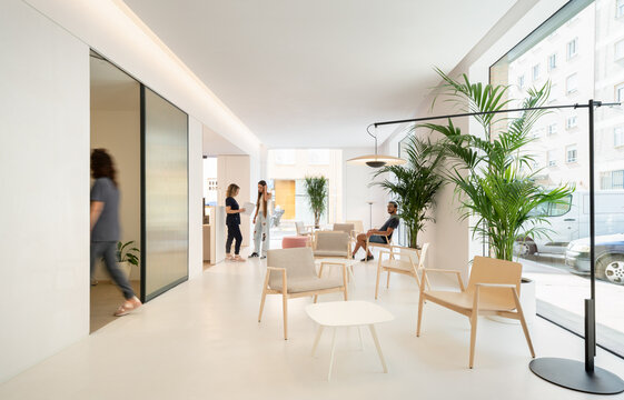Modern dental clinic waiting room with patients and staff