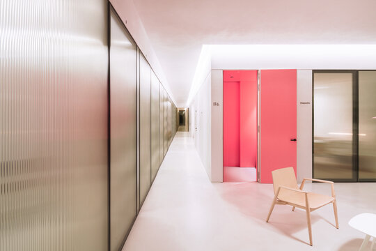 Modern dental clinic waiting room with pink accent corridor