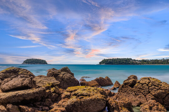 Long Exposure Seascape of Kata Beach with Rocky Shoreline and Tropical Forest, Phuket, Thailand