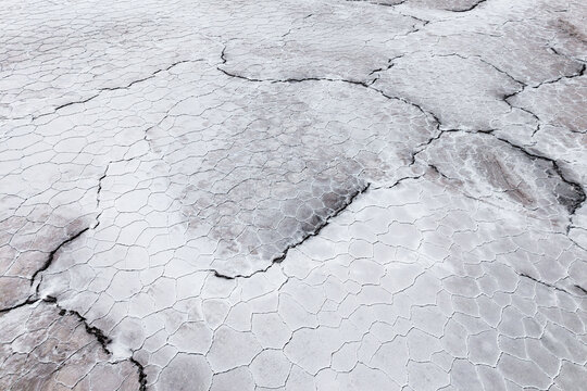 Cracked saline texture across a dry salt flat surface