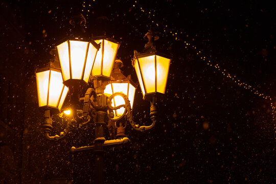Decorative vintage street lantern glowing on a winter night in Uzhhorod, Ukraine.