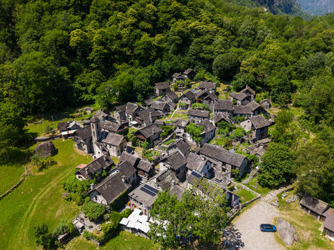 Aerial drone view of Foroglio, a historic stone village in Val Bavona, Ticino, Switzerland, surrounded by forest