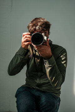 Male photographer taking self-portrait with camera in studio