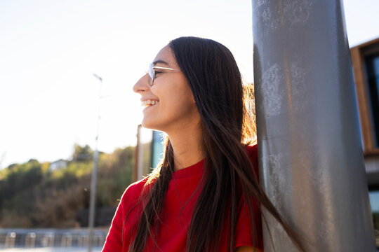 Smiling woman in red shirt outdoors at sunset