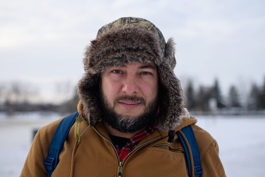 Bearded man in fur trapper hat at Sylvan Lake Alberta