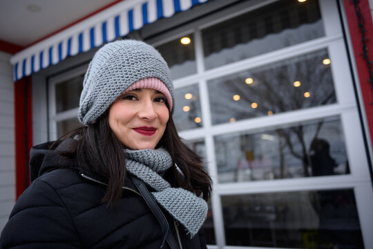 Smiling woman outside a cozy Sylvan Lake cafe in winter