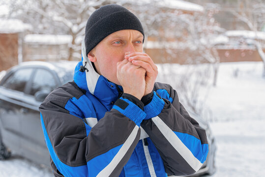 Man warm hands during winter chore in snowy yard