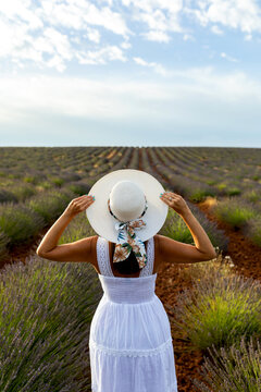 Woman in white dress among lavender fields in spring