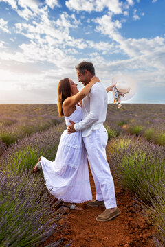 Couple embrace in lavender field during spring sunset