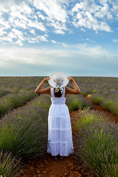 Woman in lavender field under cloudy spring sky