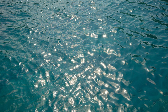 Sunlight sparkle on turquoise ocean water surface texture
